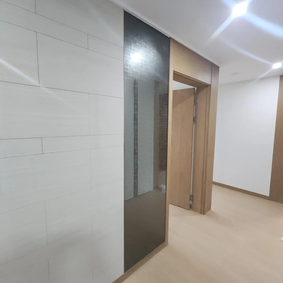 복도 타일 벽면 거울 설치 이전 어두운 유리 띠가 있는 벽