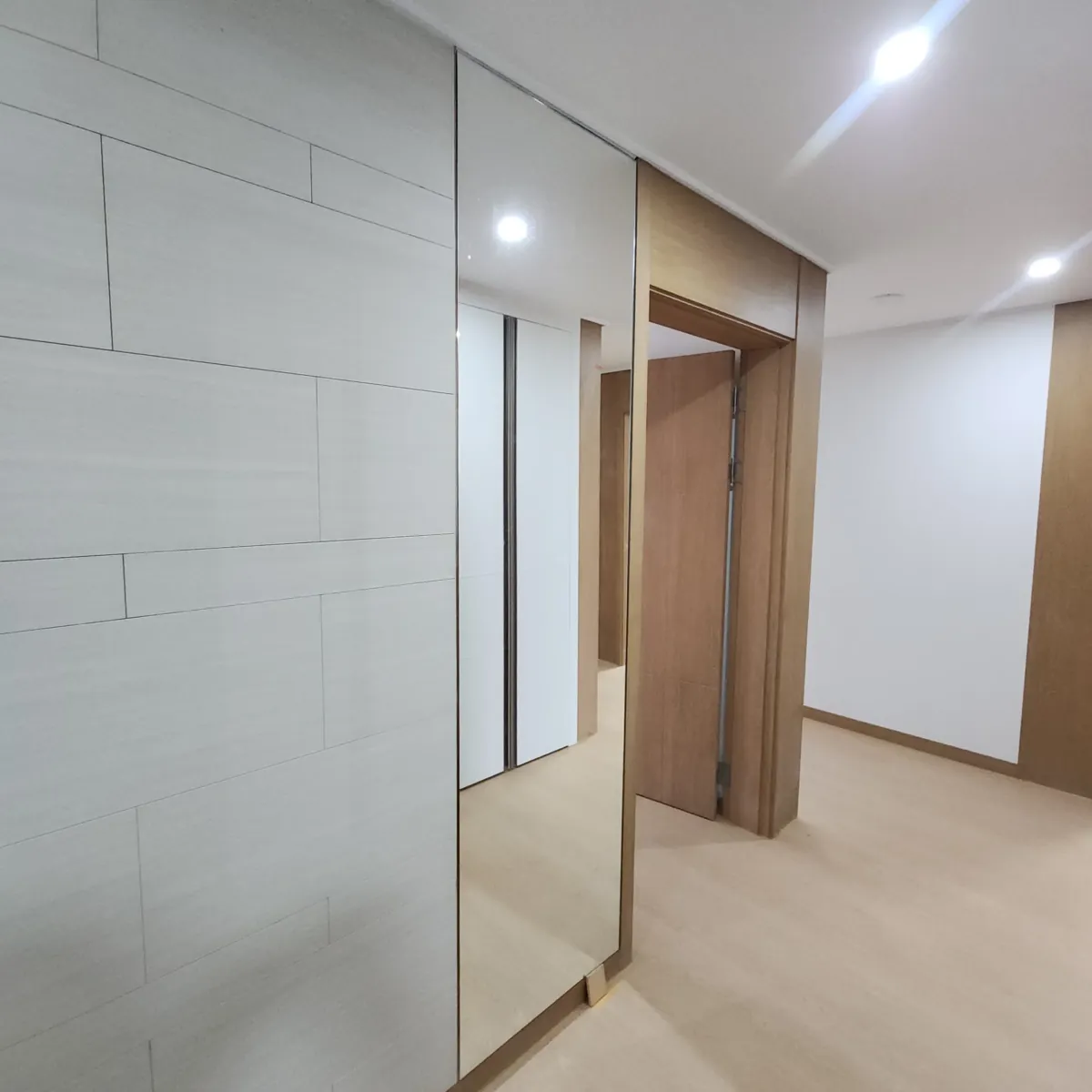 복도 벽면 거울 패널 위치 확인 진행 중 문틀 옆